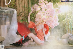 A woman in a kimono sitting on a wooden bench.