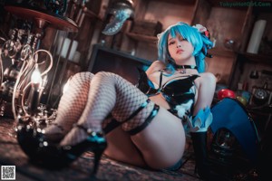 A woman with blue hair is posing in front of a mirror.