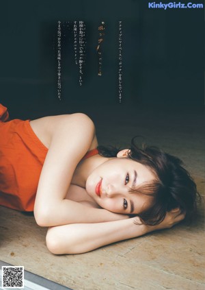 A woman in an orange dress holding a bunch of oranges.