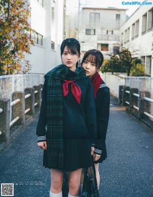 Two young women standing next to each other in a room.