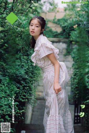 A woman in a red and white dress posing for a picture.