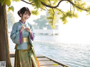 A woman in a blue and gold kimono posing for the camera.