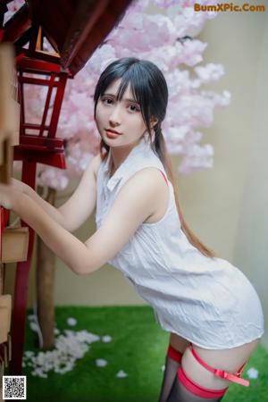 A woman in a white shirt and red stockings posing for a picture.