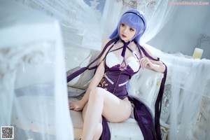 A woman with long purple hair is posing for a picture.