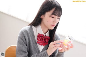 A young woman sitting at a table reading a book.