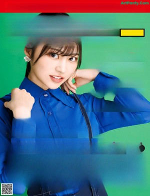 A woman in a blue shirt and suspenders posing for a picture.
