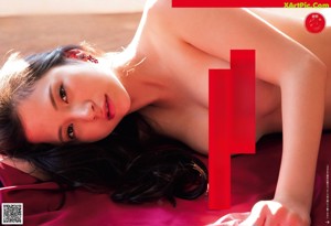 A woman laying on top of a wooden table.