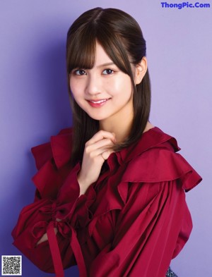 A woman in a red jacket is posing for a magazine.