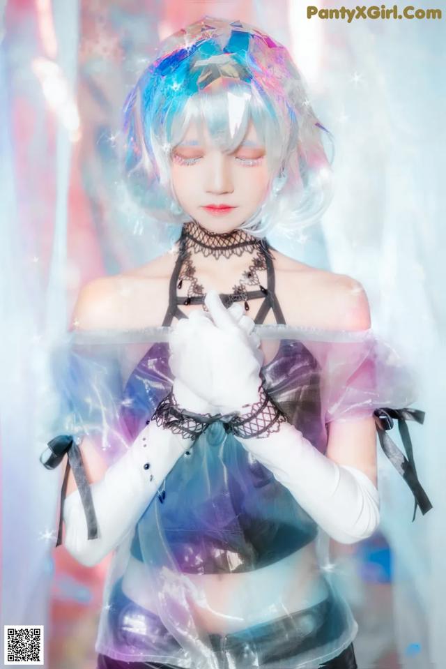 A woman with blue hair and white gloves is posing for a picture.