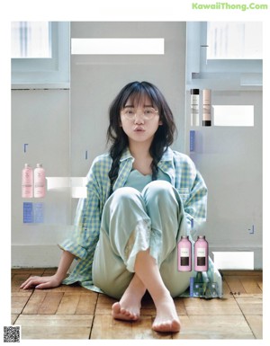 A woman laying on top of a bed next to a window.