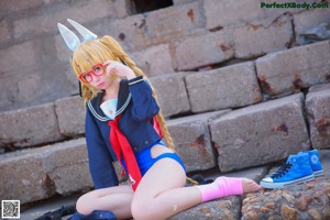 A woman in a bunny costume standing on a beach.