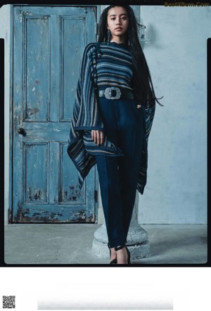 A woman standing in front of a window with her arms outstretched.