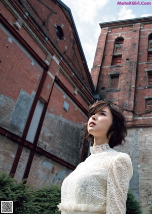 A woman with short brown hair wearing a white top.