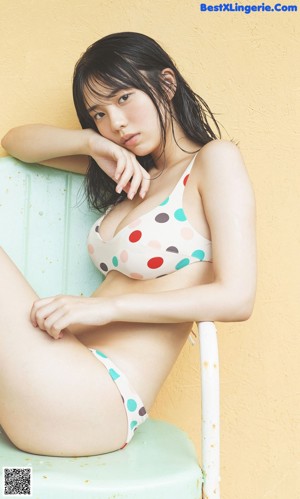 A woman in a bikini standing on a balcony.