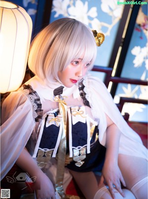 A woman sitting on a table next to a lamp.