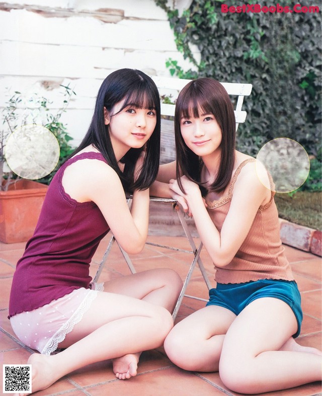 A couple of young women sitting next to each other on a patio.