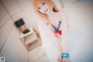 A woman with long orange hair is posing for a picture.