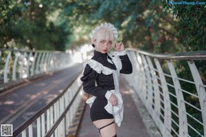 A woman in a black lingerie standing in front of a wall.