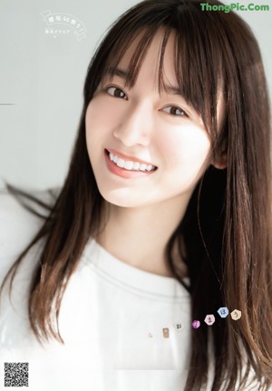 A woman in a white sweater posing for a picture.