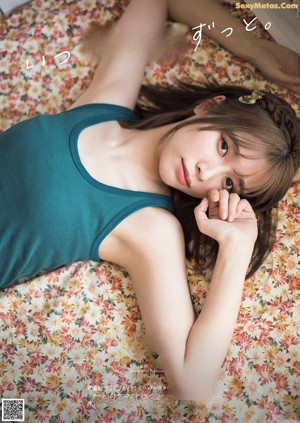 A woman sitting on a bed in a bedroom.