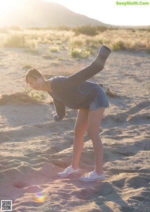 A woman sitting on the ground with a rope around her ankles.