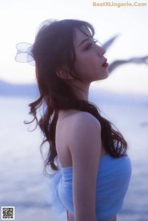 A woman in a white lingerie posing for the camera.