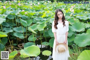 A woman in a white bikini standing in a pond.